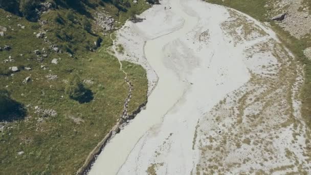 Luchtfoto wandelen groep wandelen langs de rivier van de berg. Beklimmen van een berg — Stockvideo