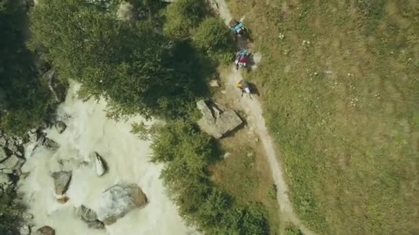 Vista dall'alto gruppo turistico a piedi sul sentiero lungo il fiume rapido in montagna — Video Stock