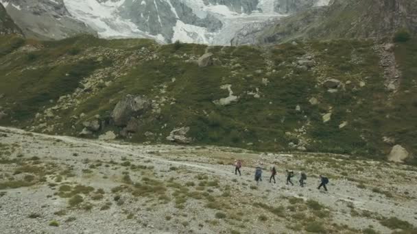 Grupo viajero caminando por el sendero de montaña vista aérea. Montaña de senderismo — Vídeos de Stock