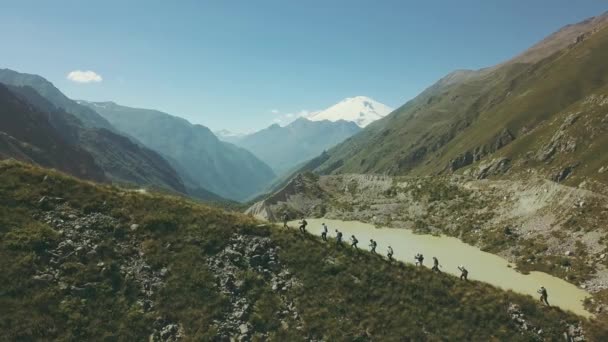 Panoráma túra az emberek sétálni a hegyi kilátással a tóra és a hó-csúcs — Stock videók