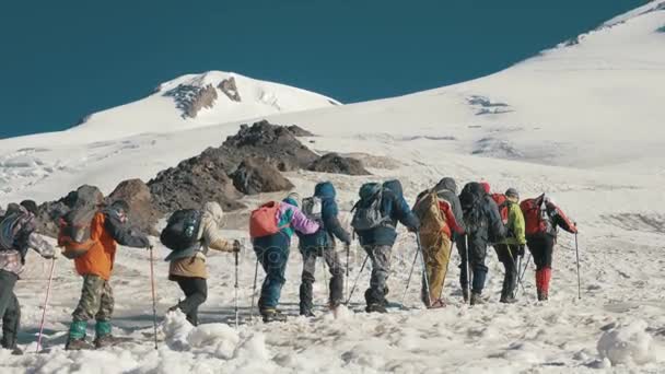 Grupo turístico caminhando em trilha de neve na montanha. Inverno paisagem de montanha — Vídeo de Stock