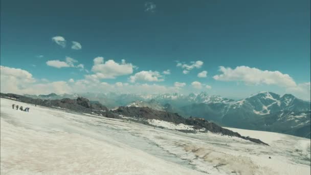 Schöne Szenetouristen, die auf Schneebergen wandern. Winterwandern in den Bergen — Stockvideo