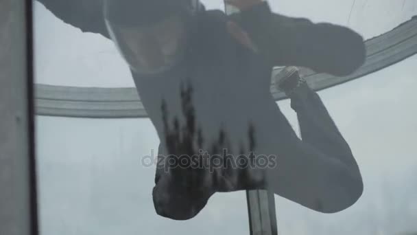 Mannen fallskärmshoppare flyger i vindtunnel. Utbildning hoppning inomhus fallskärmshoppning tunnel — Stockvideo