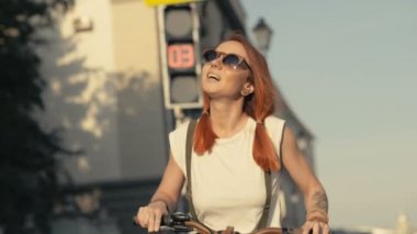 Ampul arka plan üzerinde bisiklet duran kırmızı saçlı kadın