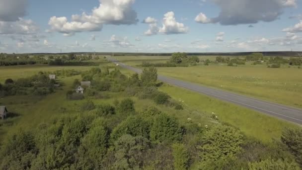 Autópálya közúti forgalom a völgyben. Antenna hajtás egy autópálya közúti forgalom autók egy völgyben fekszik, a zöld fű mező, és a fák a természetben — Stock videók