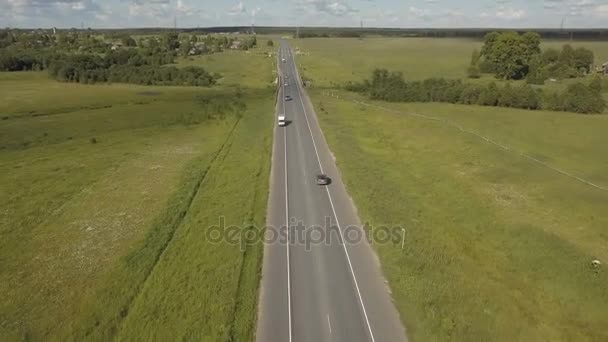 Circulation routière dans une vallée. pousse aérienne d'une route avec des voitures de circulation dans une vallée avec champ d'herbe verte et des arbres dans la nature — Video