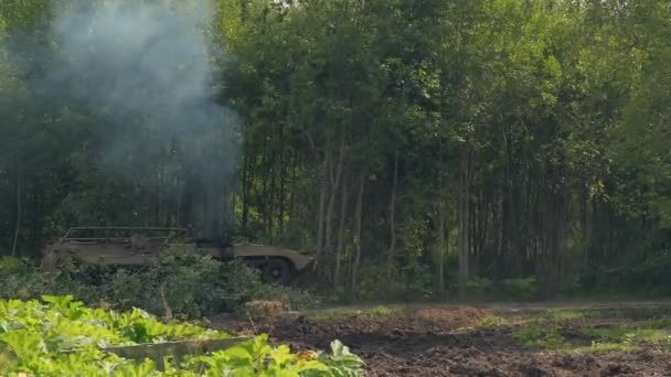 Военный танк ломает зеленые деревья, чтобы построить дорогу в лесу для борьбы с врагом — стоковое видео