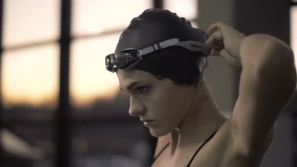 Γυναίκα κολυμβητής βάζοντας στο κεφάλι γυαλιά για κολύμβηση σε πλωτή πισίνα — Αρχείο Βίντεο