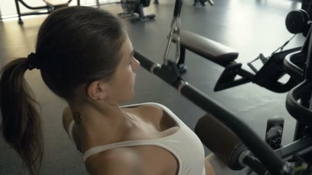 Athlete woman lifting weights on fitness exercise equipment in health club — Stock Video