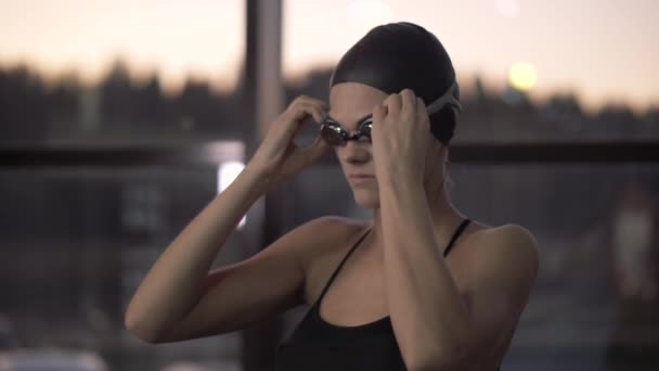 Mujer nadadora poniendo gafas en la cara para nadar bajo el agua en la piscina — Vídeos de Stock