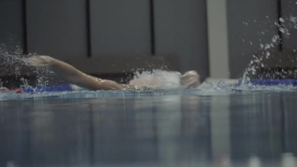 Γυναίκα καταλληλότητας που επιπλέουν πεταλούδα εγκεφαλικό επεισόδιο σε διαφανή νερό θέα μπροστά στην πισίνα — Αρχείο Βίντεο