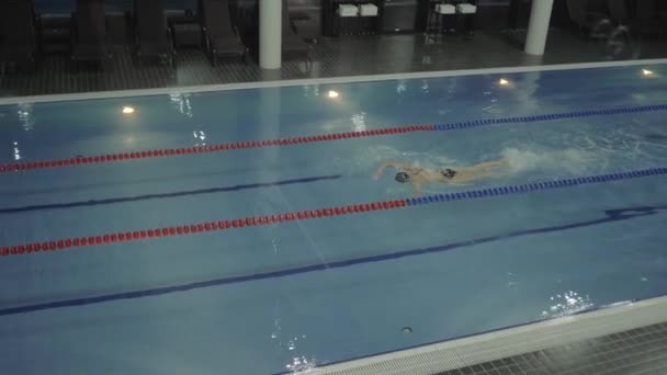 Mujer profesional nadador flotante golpe de arrastre en el agua de lujo piscina — Vídeo de stock