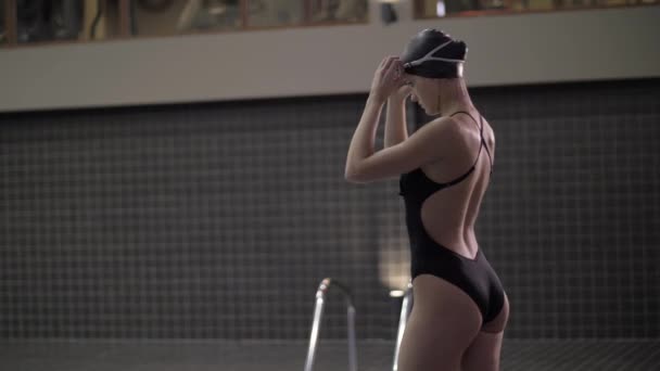 Mujer joven nadadora en traje de baño preparada inmersión en agua flotando en la piscina — Vídeos de Stock