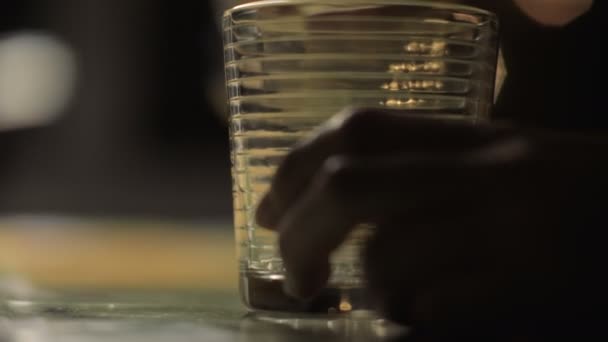 Closeup el dökme alkol içme ve masanın üzerine koyarak cam şişe — Stok video