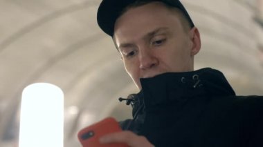 Metro escalato ağlarda gözatmak için cep telefonunuzun portre genç adam