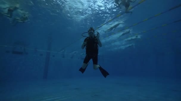 Mergulhador em máscara de mergulho e equipamento de mergulho nadando debaixo d 'água piscina profunda — Vídeo de Stock