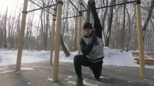 Hombre guapo entrenamiento ejercicios de entrenamiento con expansor en el campo de deportes — Vídeo de stock