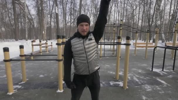 Сильный человек делает упражнения с экспандером на открытом воздухе — стоковое видео
