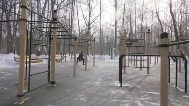 Homem fisiculturista treinamento crossfit exercício em campo de esportes no parque de inverno — Vídeo de Stock