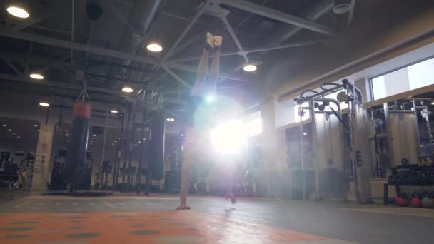 Сильный человек ходит под рукой во время тренировки по кроссфиту в фитнес-клубе — стоковое видео