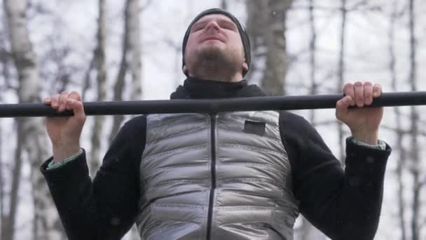 Homme barbu faisant l'exercice pull up pendant l'entraînement en plein air sur le terrain de sport — Video