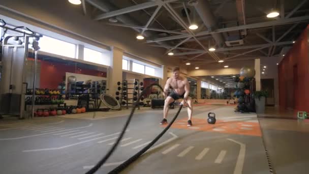 Ejercicio de entrenamiento de hombre atleta con cuerdas en el gimnasio — Vídeo de stock