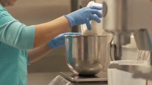 Bäckerin gießt in Restaurant Mehl in Schüssel, die auf Küchenwaage steht — Stockvideo