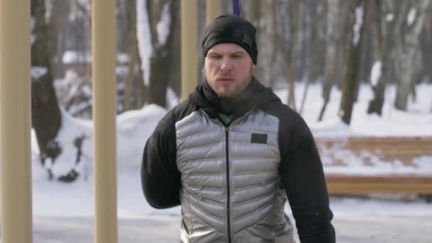 Exercice de squat d'entraînement d'homme barbu pendant l'entraînement d'hiver sur le terrain de sport — Video