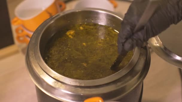 Chef main ouverture casserole et verser la soupe chaude dans un bol dans la cuisine du restaurant 