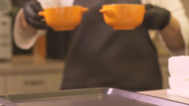 Woman cook putting on tray two bowls with hot soup for serve in restaurant — Stock Video