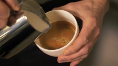 Barista dökülen süt sıcak kahve ve kapuçino kafede köpük yapım yakın çekim