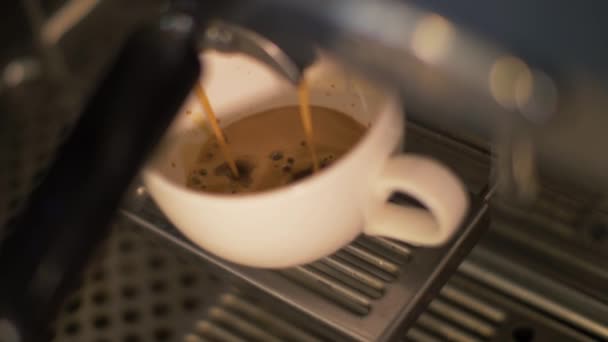 Кофе наливают в чашку из кофеварки в ресторане крупным планом — стоковое видео