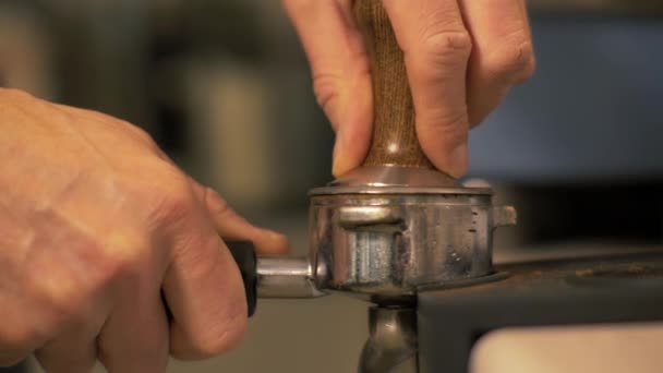 Close-up van barista indrukken van gemalen koffie voor de bereiding in de coffeeshop — Stockvideo