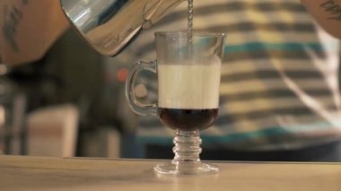 Cafe barista dökülen süt kahve cam fincan sütlü kahve dükkanında hazırlama