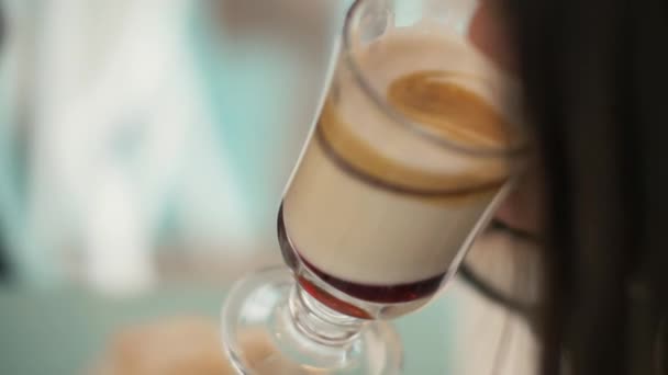 Närbild kvinna dricker kaffe latte från glas cup i cafeterian — Stockvideo