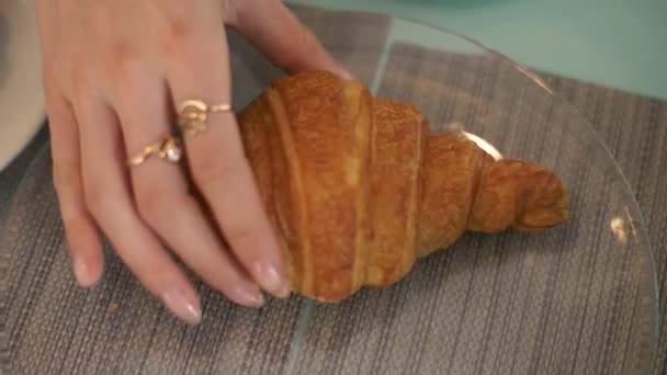 Női kéz véve croissant pohár tányér asztal, kávézó közelről — Stock videók