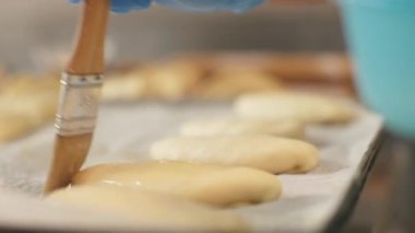 Baker yakından fırça ile yumurta karışımı fırın mutfak için köftesi üzerinde uğratan