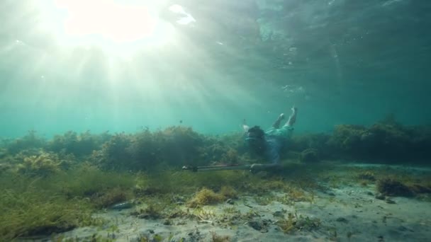 A poor Asian spearfisherman trying to catch a fish underwater for a living — Stock Video