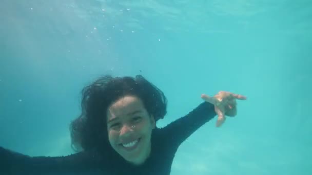 Young attractive funny girl with child smiling aand shouting diving underwater. — Stok video