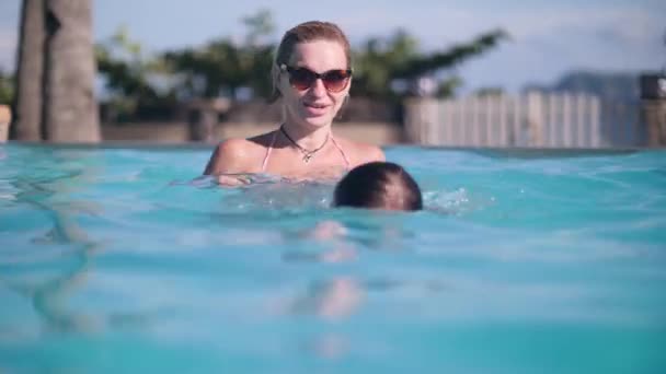 Anya játszik a gyermek lánya lány a medencében, búvárkodás és fröccsenő együtt. — Stock videók