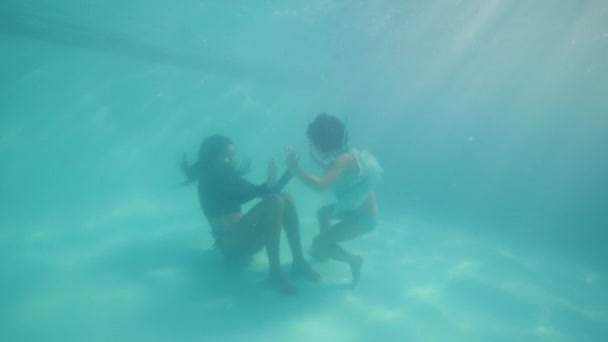 Mom and daughter playing together diving underwater in swimming pool. — 비디오