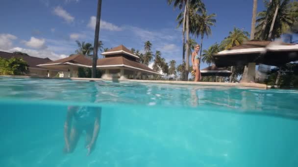 Menina nadando sozinha na piscina azul em um resort tropical . — Vídeo de Stock