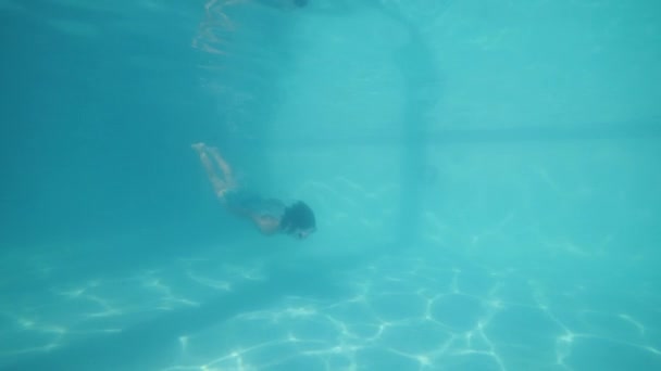 Active petite fille courageuse nageant sous l'eau dans la piscine . — Video