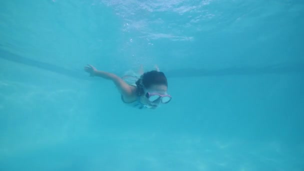 Niña en la natación máscara de buceo bajo el agua en la piscina y mirando a la cámara . — Vídeo de stock