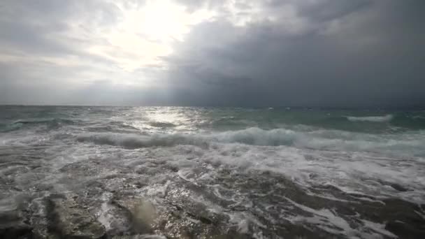 Zeegezicht: Surf golven met schuim spatten op rotsachtige kust. — Stockvideo