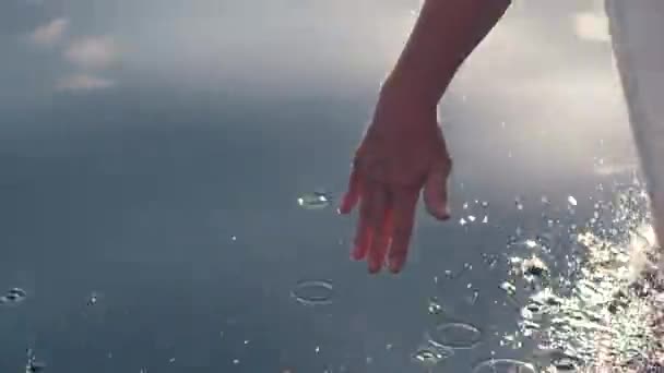 Een mannetjes hand opknoping op de rand van een zeilboot voelen de plons van het water. — Stockvideo