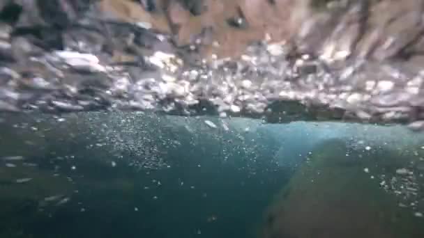 Slow Motion: Ung kvinna dyker huvudet först i vattnet under det glasartade vattenfallet — Stockvideo