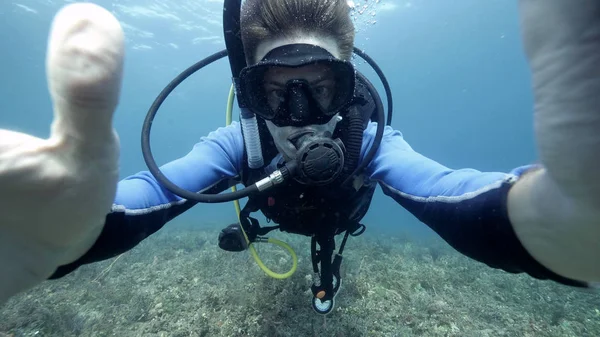 Undervattensselfie foto av en manlig suba dykare i det blå havet. — Stockfoto