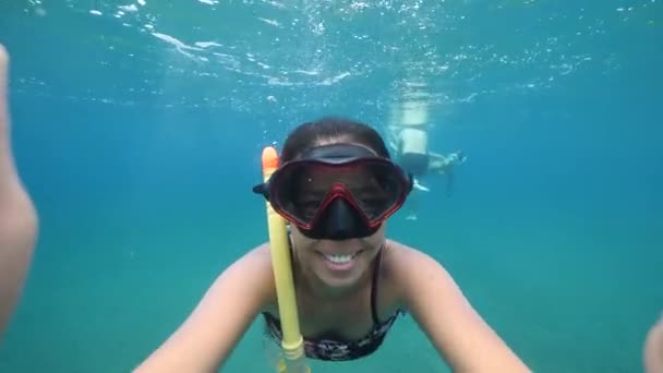 Undervattensflicka i snorklande mask och bikini håller kameran med stort leende — Stockvideo