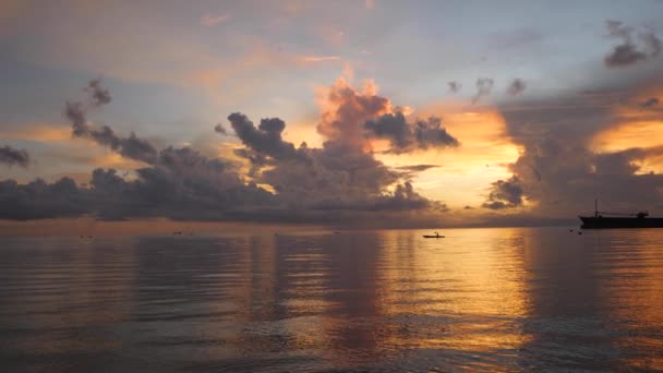 Ελκυστικά ζωντανά σύννεφα του ουρανού πάνω από τον ωκεανό την αυγή με ένα πλωτό αλιευτικό σκάφος. — Αρχείο Βίντεο